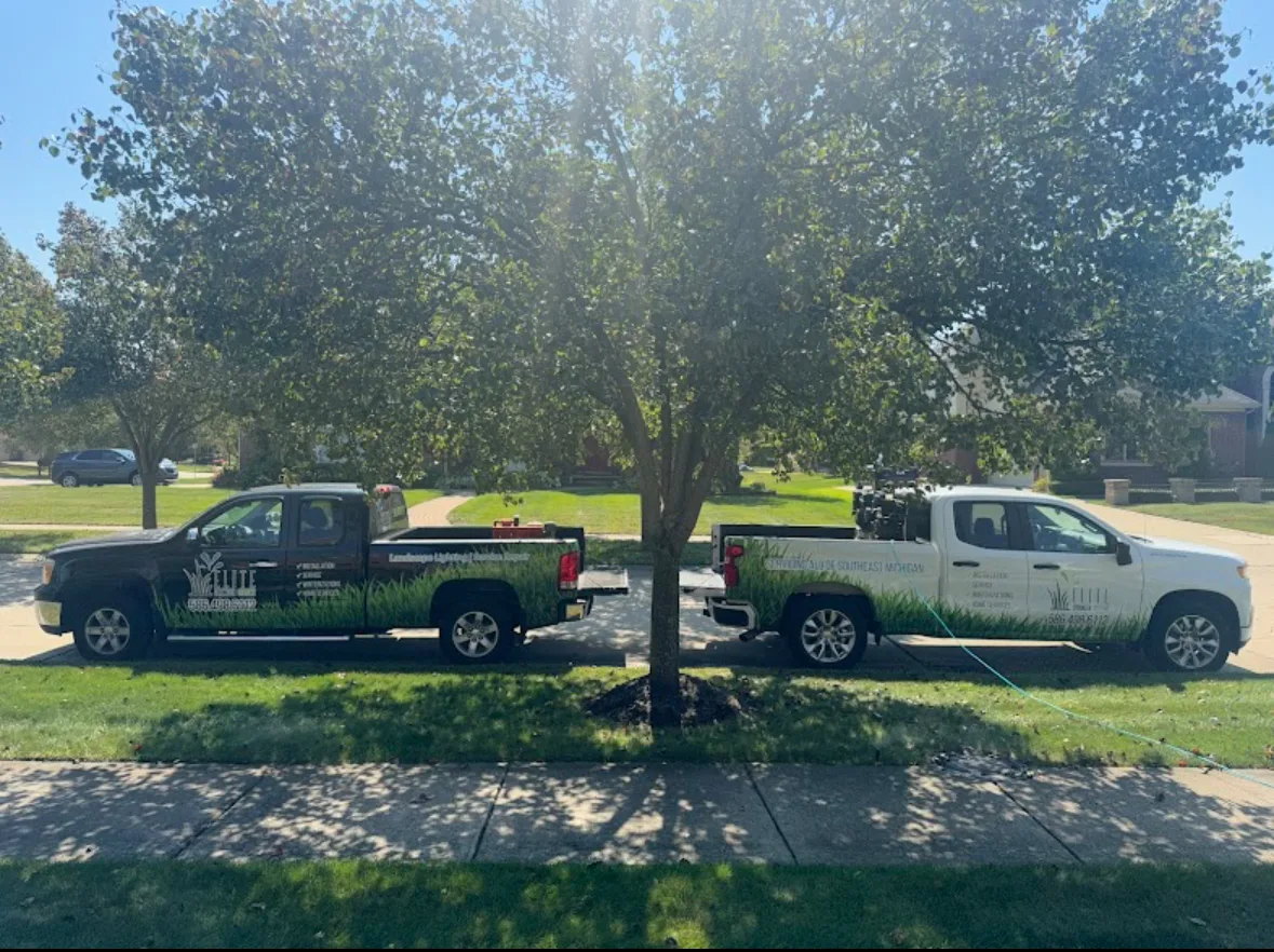 Elite Sprinkler Systems fleet service trucks at a Metro Detroit residential property