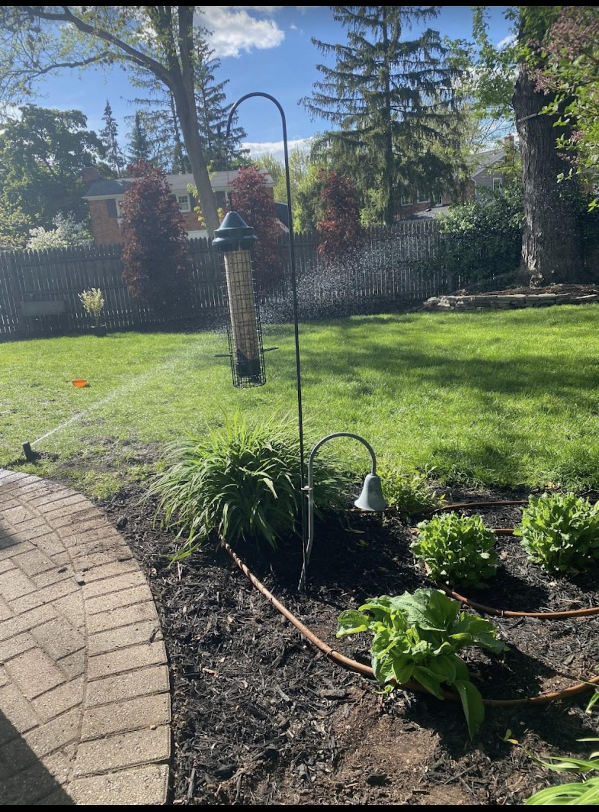 Elite Sprinkler Systems drip irrigation system watering garden beds in a Michigan backyard — precision drip irrigation services.