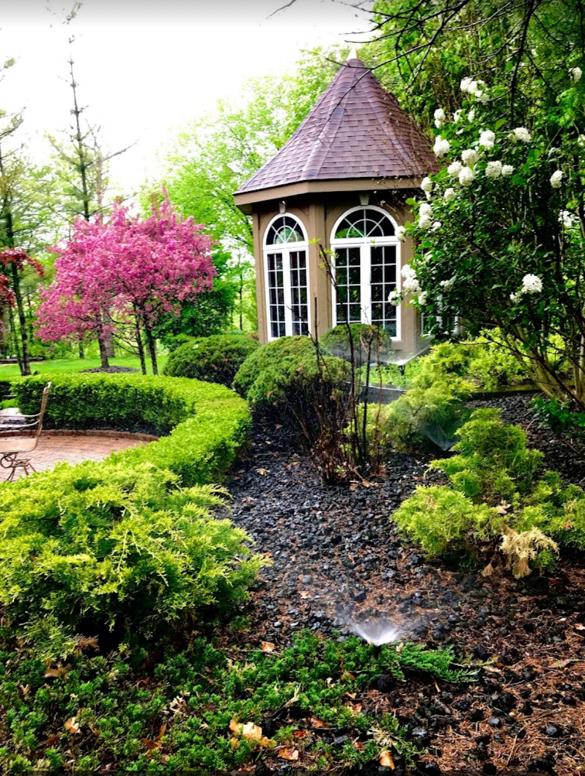 Beautiful garden gazebo with active sprinkler misting in Michigan — Elite Sprinkler Systems.