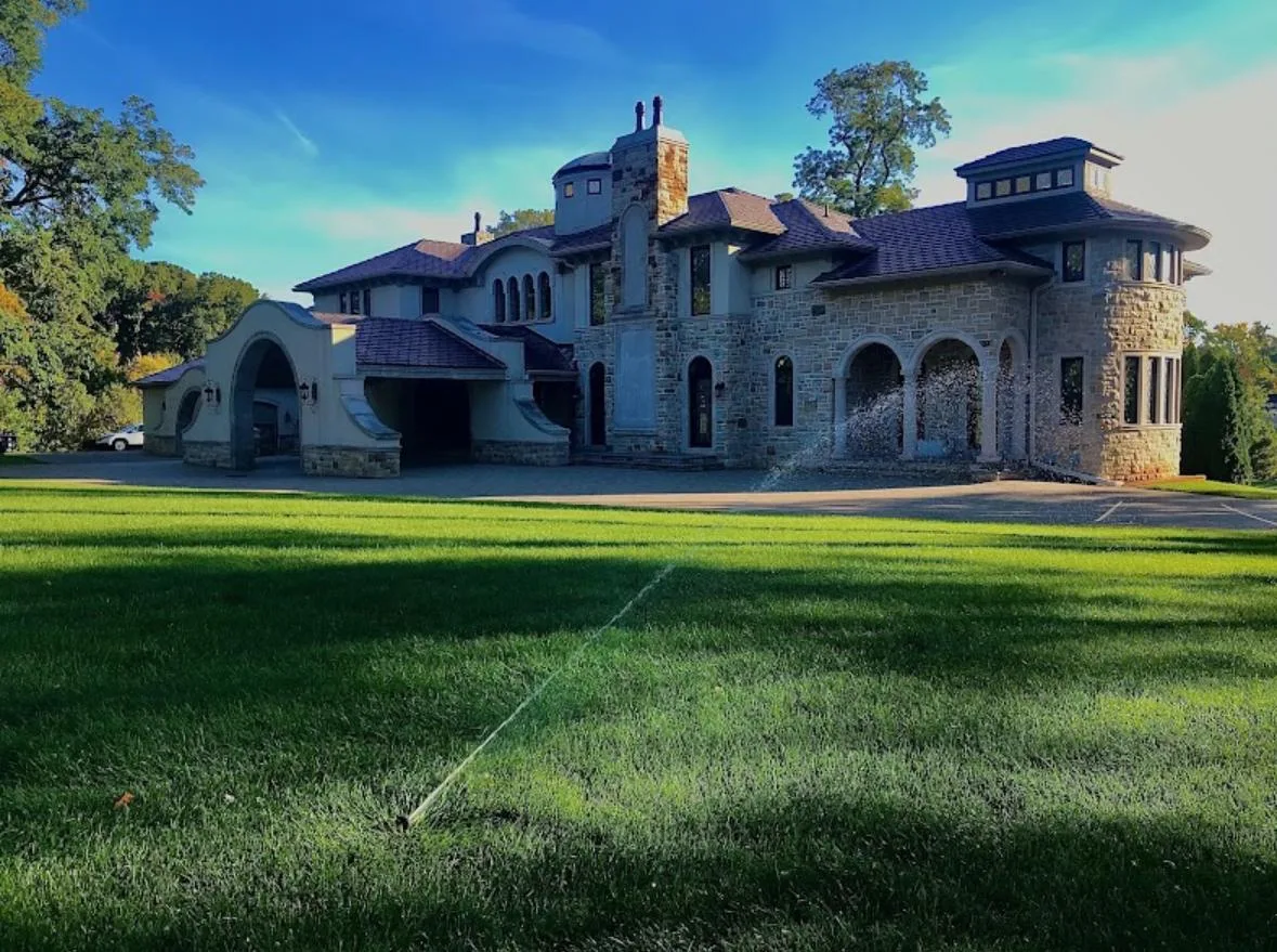 Stone estate with irrigation system at golden hour in Troy, Michigan — Elite Sprinkler Systems